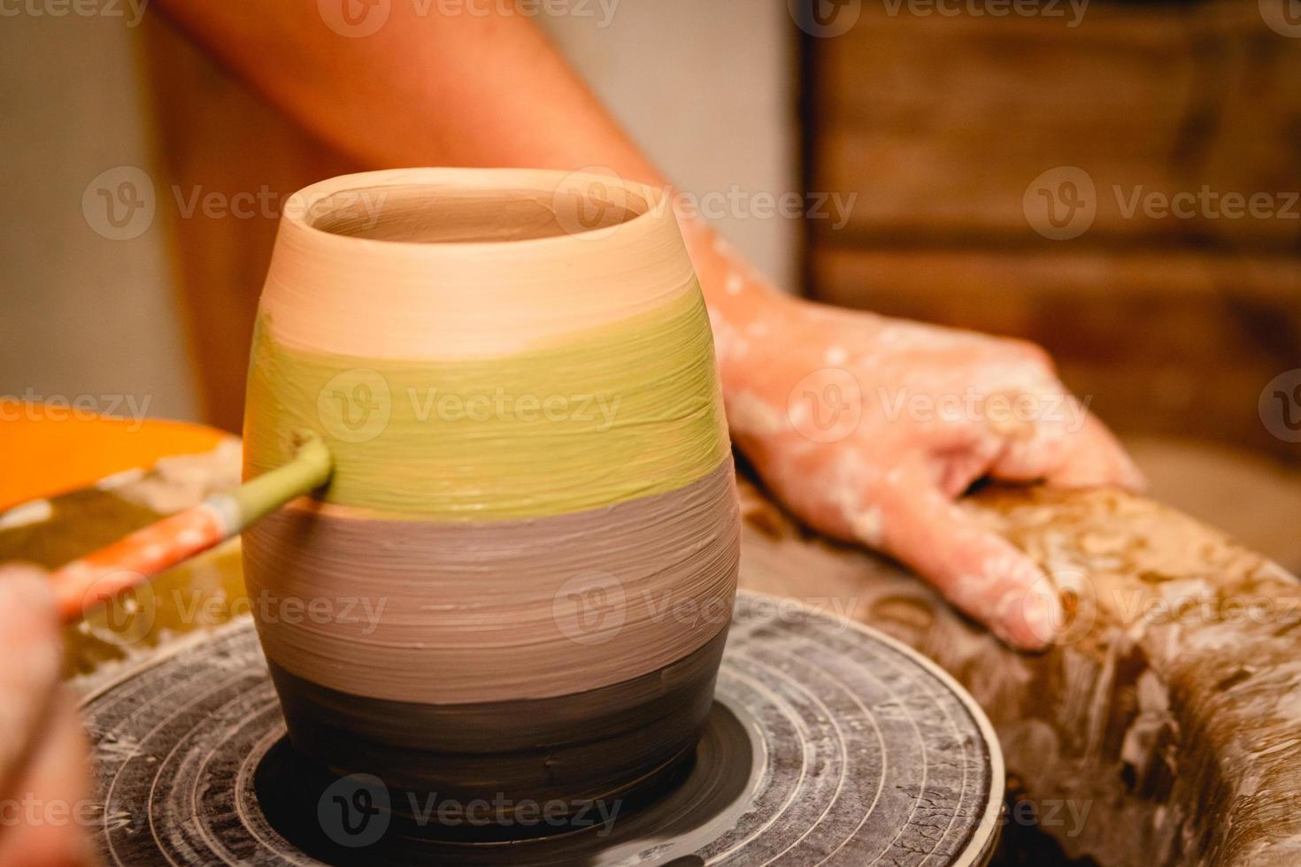 oleiro trabalhando na roda de oleiro com argila. processo de fabricação de utensílios de mesa de cerâmica na oficina de cerâmica. foto
