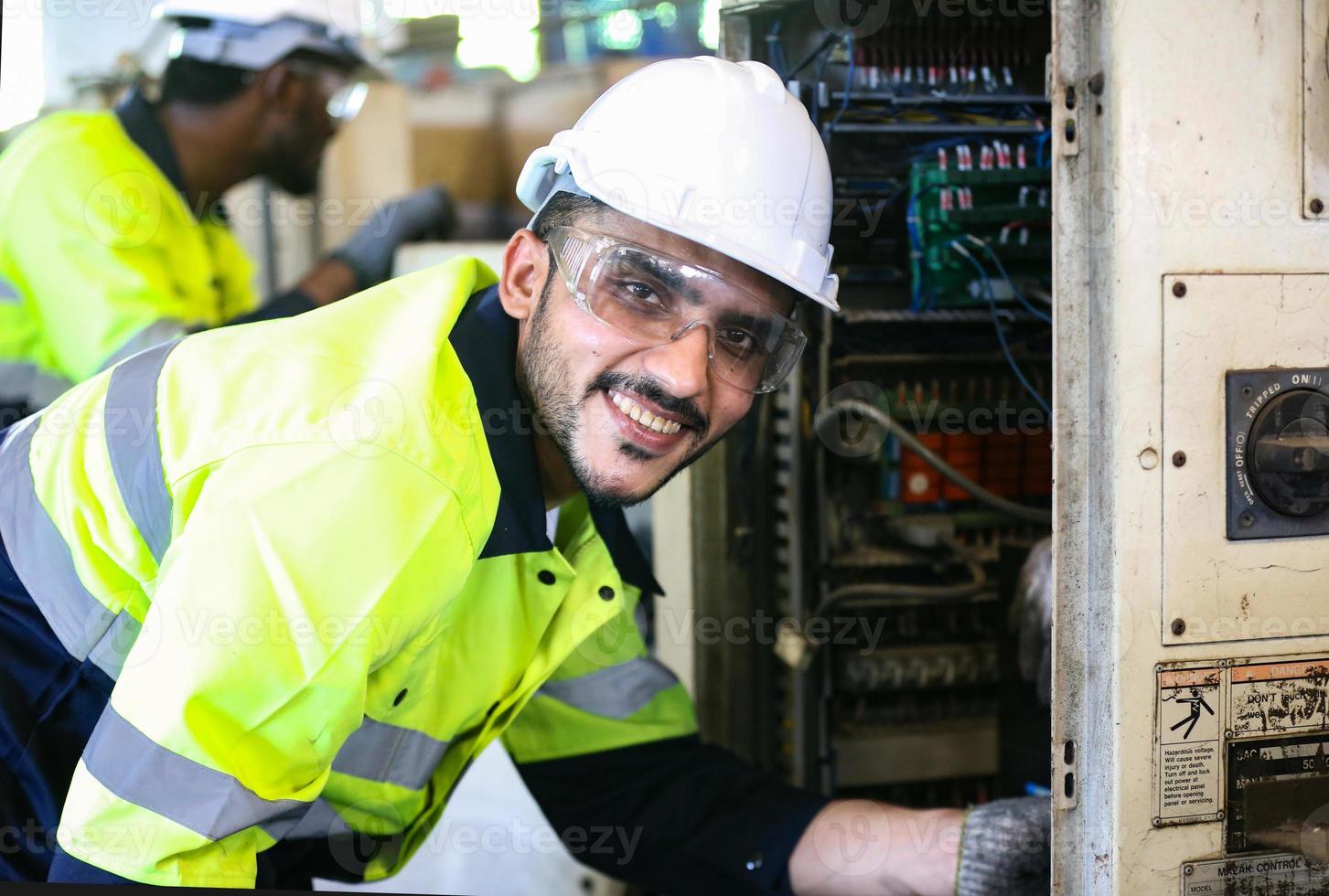 engenheiros de manutenção está trabalhando na frente do reparo automatizado de máquinas cnc em uma lista de verificação de manutenção na linha de produção. foto