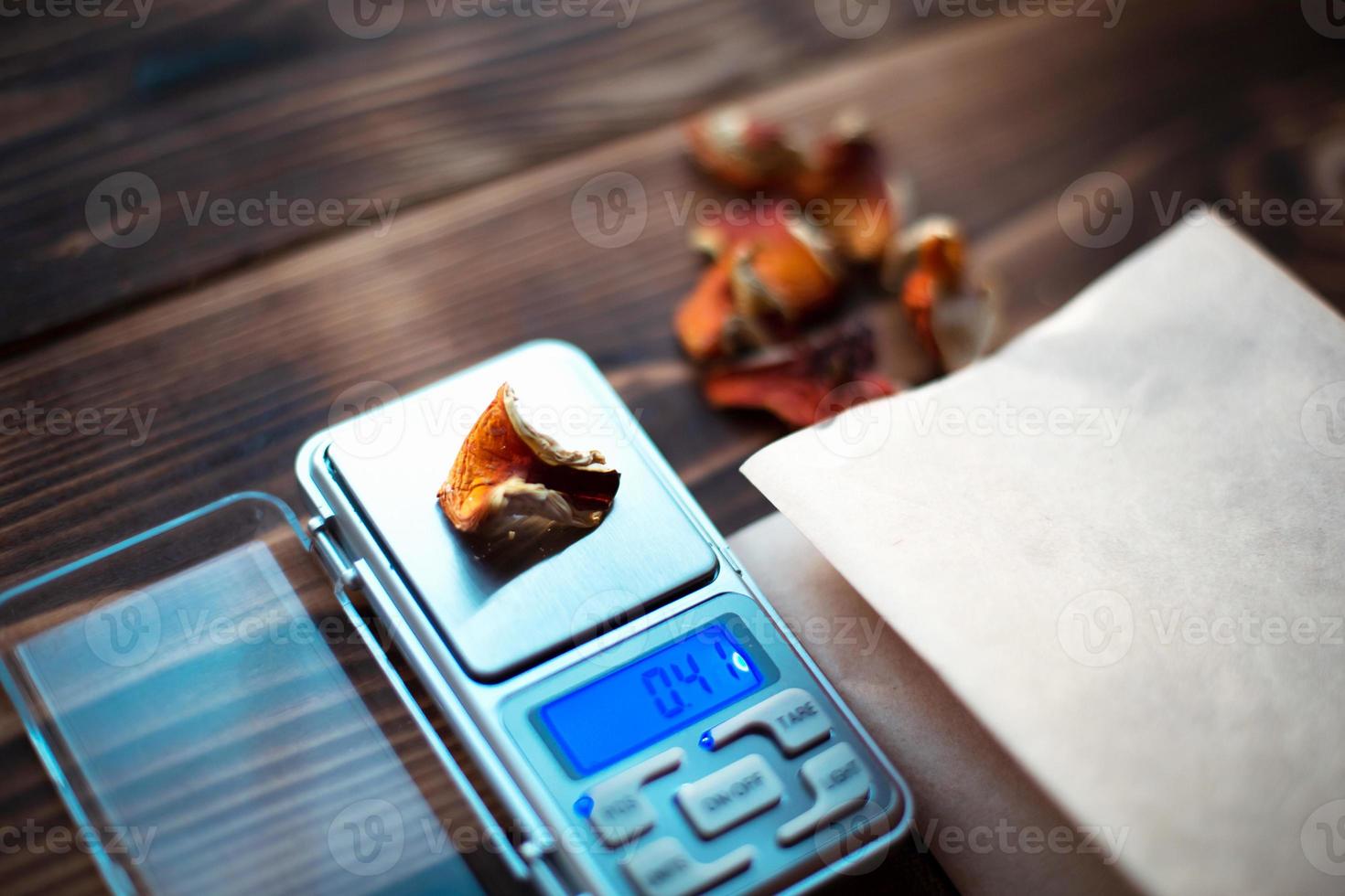 pedaços secos de cogumelo agárico na mesa com escamas. medição de microdose, micrograma de substância narcótica psicodélica e terapêutica em amanita muscaria venenosa. microdosagem, psicotrópico foto