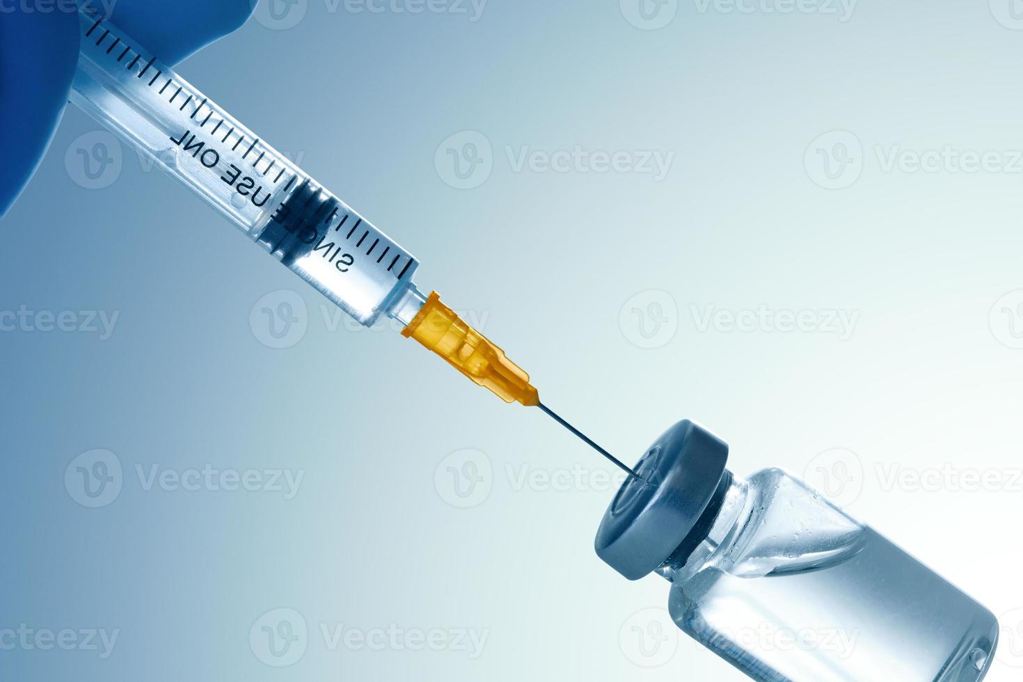 seringa médica com uma agulha e um bollte com vacina. foto