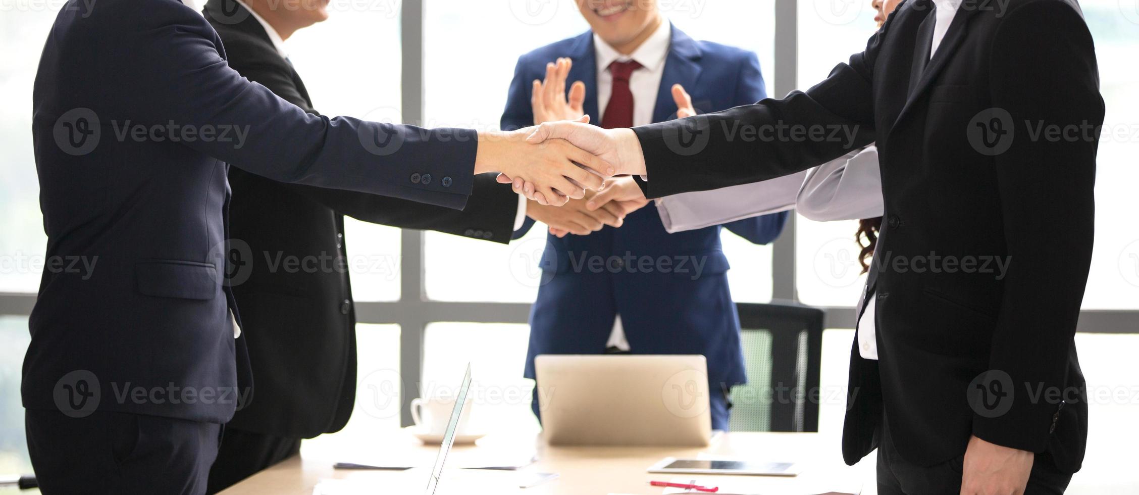 empresários apertando as mãos no escritório moderno terminando reunião bem sucedida foto