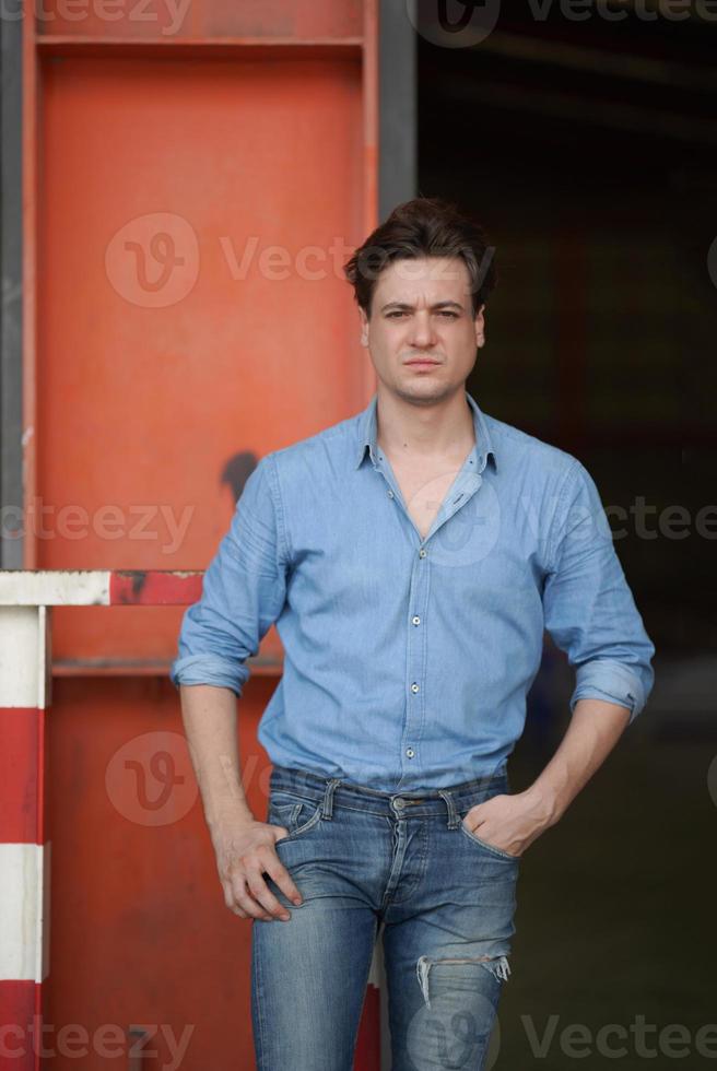 retrato de homem bonito na camisa azul em pé ao ar livre. foto
