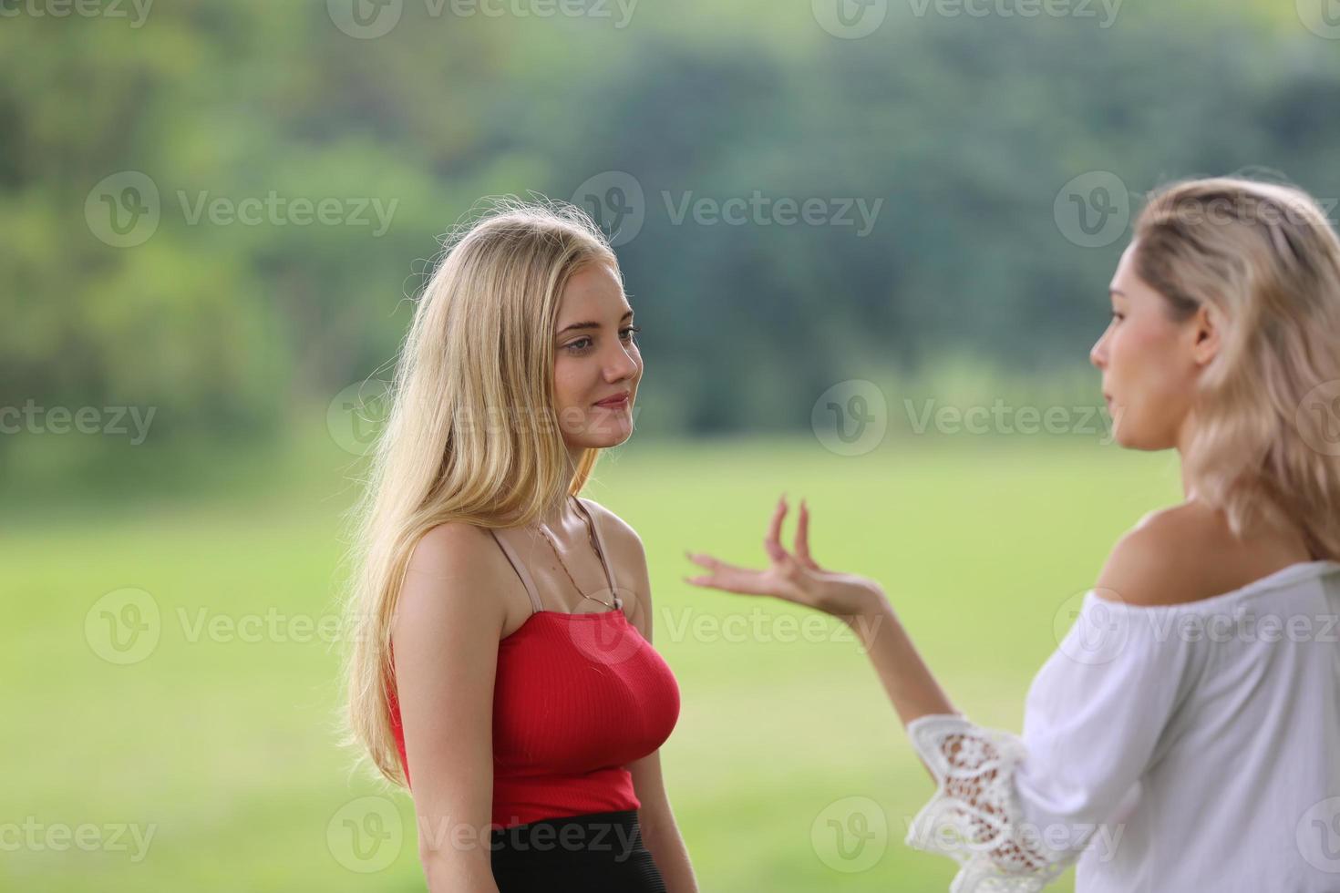 Feche o retrato da menina de beleza com cabelos brancos esvoaçantes curtindo a natureza ao ar livre, em um campo. cabelos loiros voando no vento. brisa brincando com o cabelo da menina. rosto de mulher jovem e bonita foto