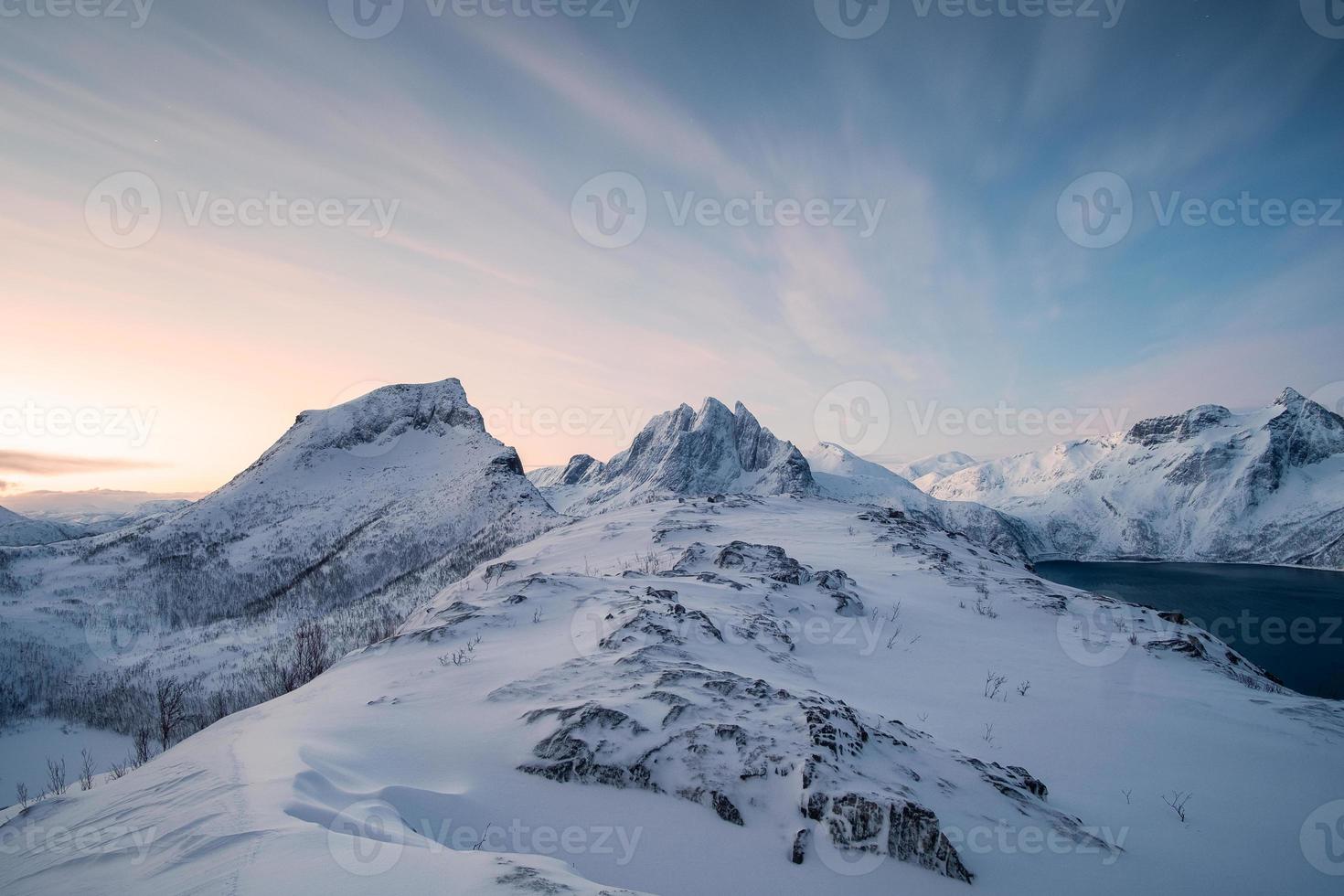 montanha segla na colina nevada com céu colorido ao nascer do sol na ilha senja foto