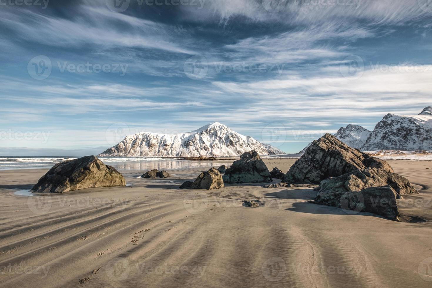 areia de sulco natural com montanha de neve e céu azul na praia de skagsanden foto