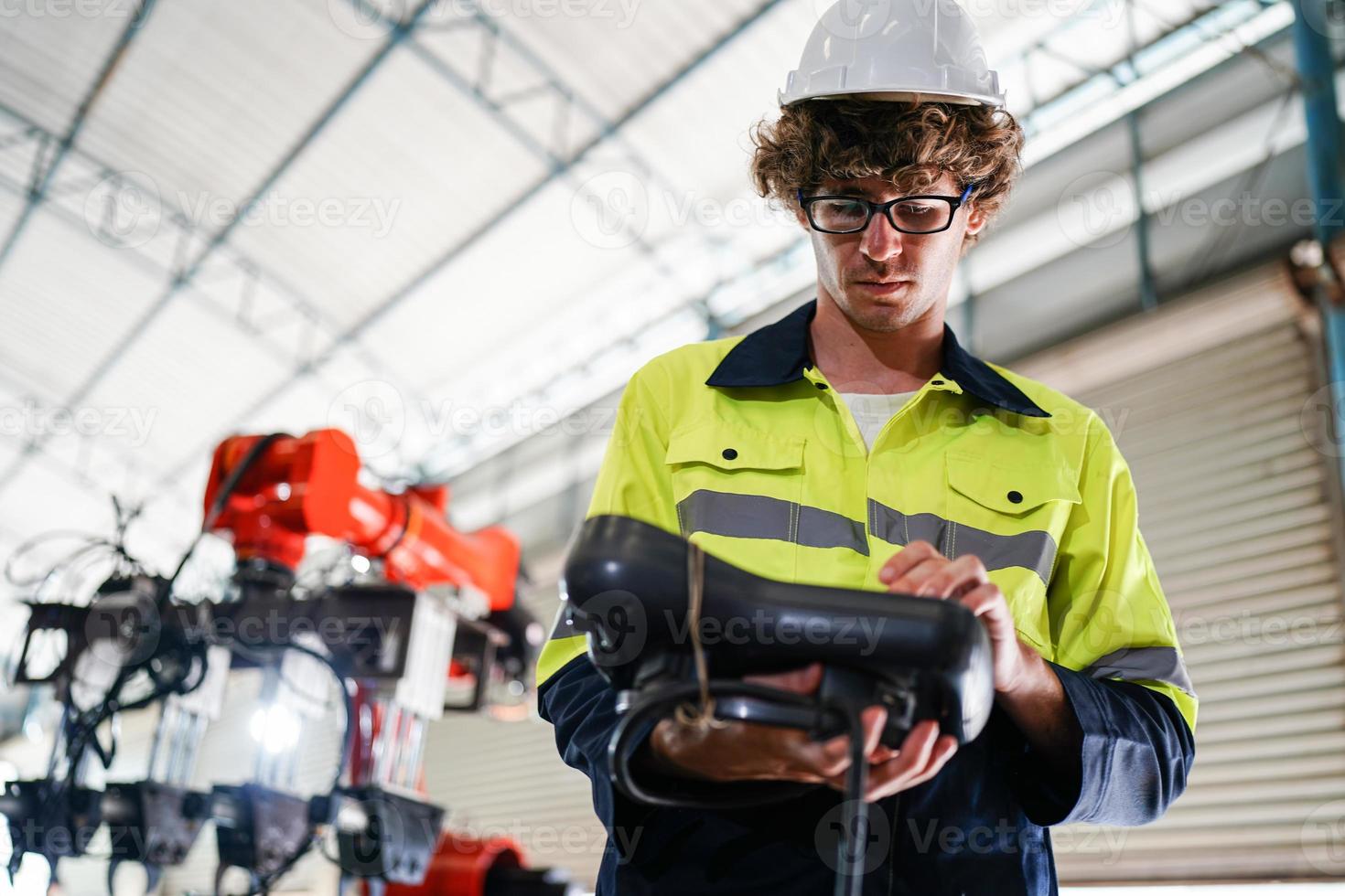 funcionário de fábrica industrial profissional trabalhando com peça de máquina, verificando e testando equipamentos industriais e braços robóticos em grande fábrica de plantas de fabricação de fios e cabos eletrônicos elétricos foto