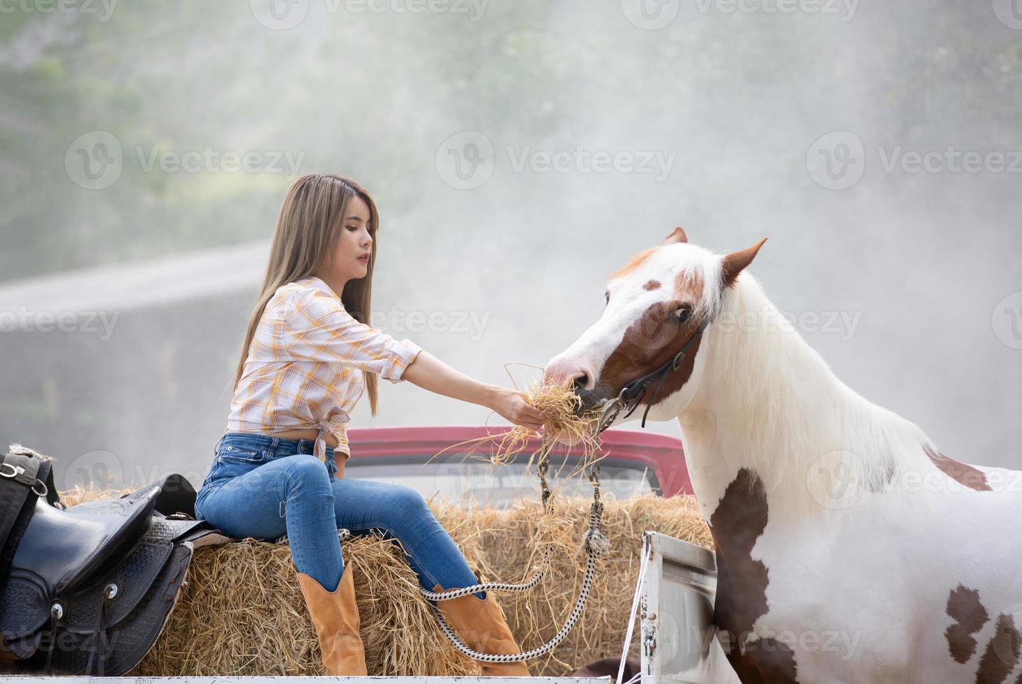 jovem e bonita com seu cavalo na luz do sol à noite. fotografia ao ar livre com garota modelo de moda. humor de estilo de vida foto