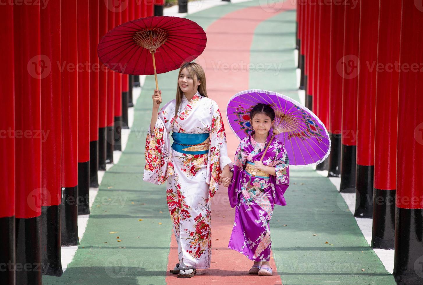 jovem garota asiática vestindo roupas tradicionais japonesas de quimono e guarda-chuva vermelho. foto