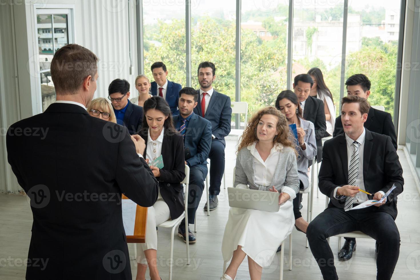 orador dando apresentação no salão. auditório ou sala de conferências. vista traseira de participantes não reconhecidos na audiência. evento de conferência científica, treinamento foto