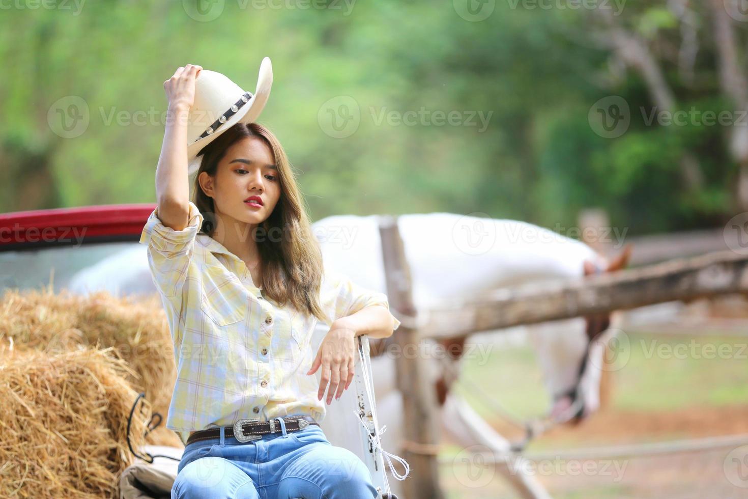 jovem e bonita com seu cavalo na luz do sol à noite. fotografia ao ar livre com garota modelo de moda. humor de estilo de vida foto