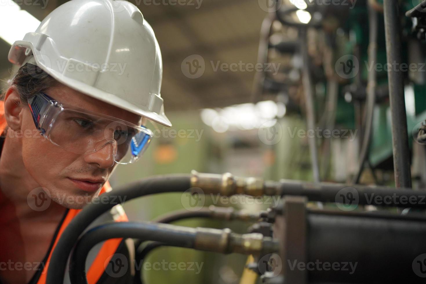 engenheiros de manutenção está trabalhando na frente do reparo automatizado de máquinas cnc em uma lista de verificação de manutenção na linha de produção. foto