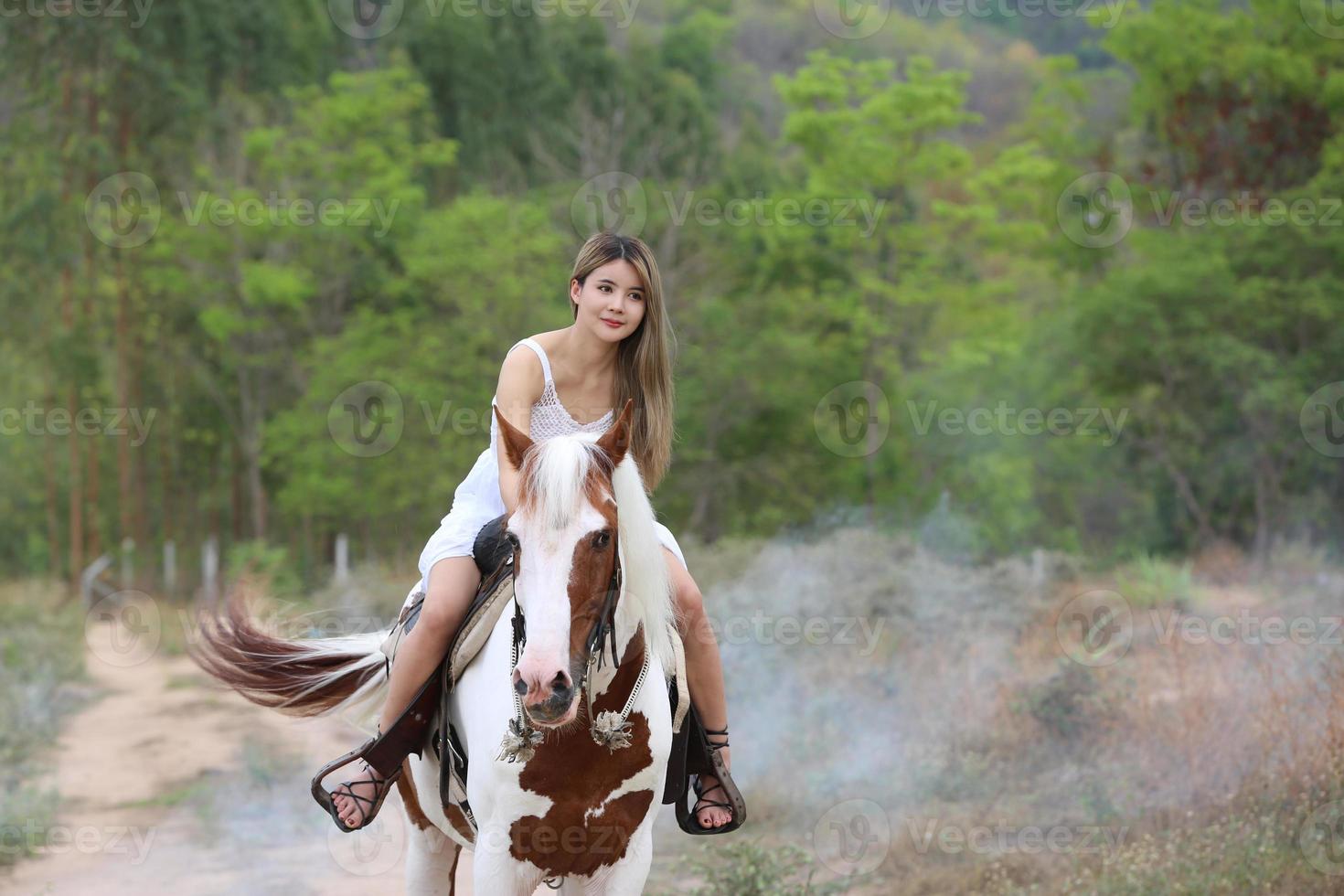 jovem e bonita com seu cavalo na luz do sol à noite. fotografia ao ar livre com garota modelo de moda. humor de estilo de vida foto