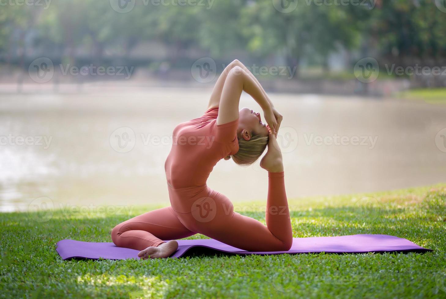 loira bonita ativa fazendo exercícios de ioga e treino ao ar livre. foto