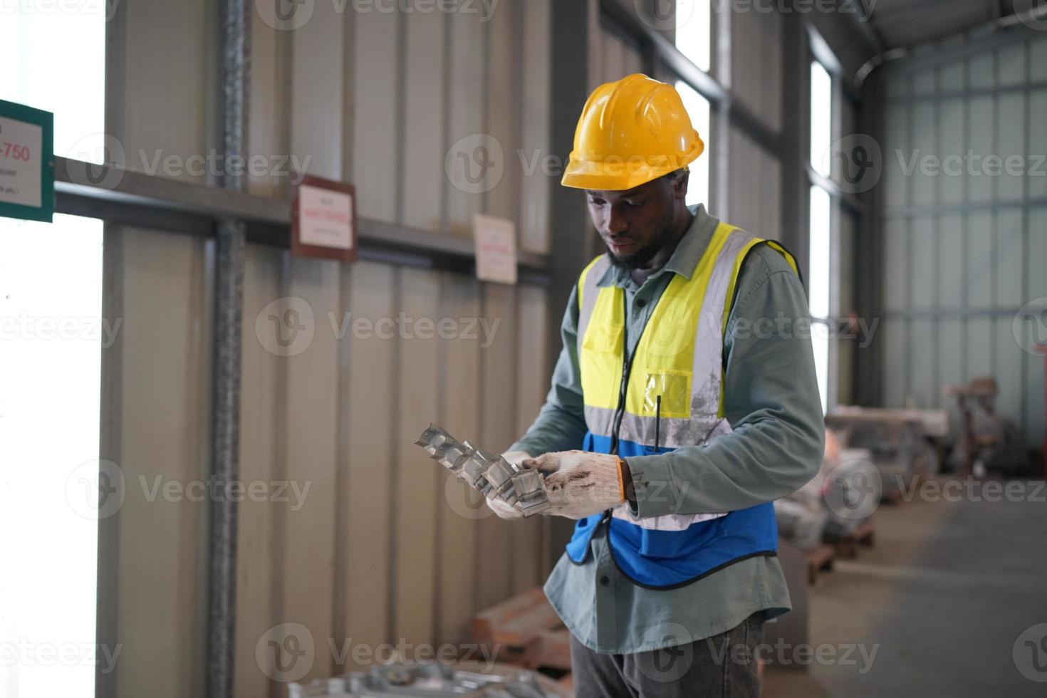 engenheiro industrial de homens usando um capacete de segurança em pé em uma fábrica industrial pesada. a manutenção procurando trabalhar em máquinas industriais e verificar a configuração do sistema de segurança na fábrica. foto