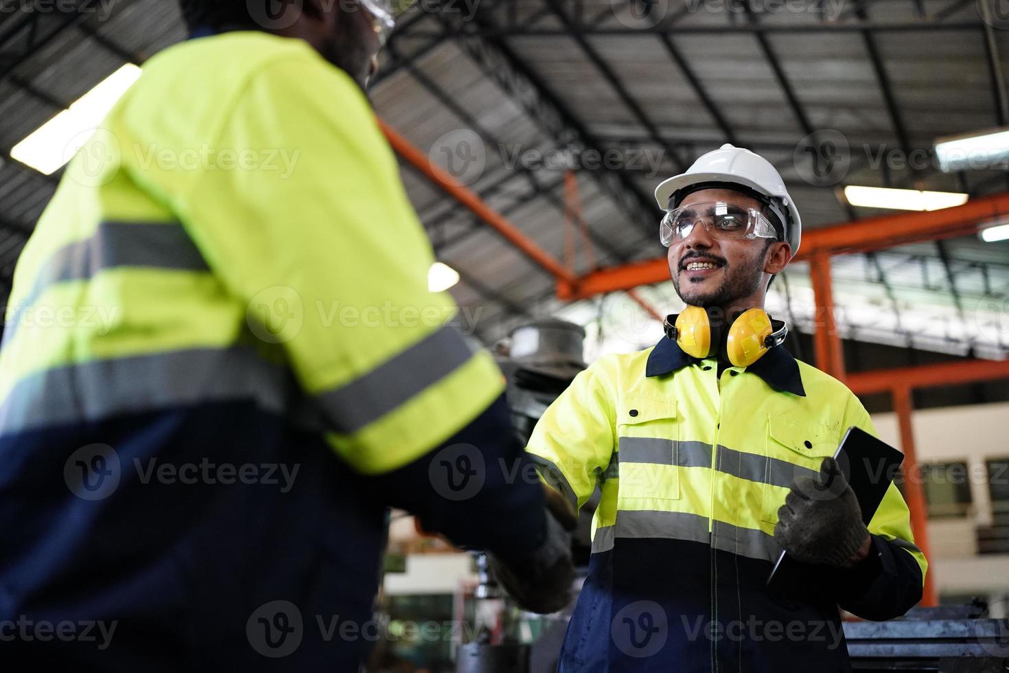 engenheiros de manutenção está trabalhando na frente do reparo automatizado de máquinas cnc em uma lista de verificação de manutenção na linha de produção. foto