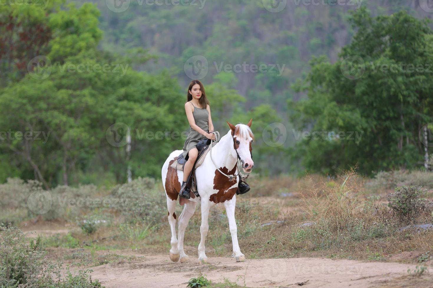 jovem e bonita com seu cavalo na luz do sol à noite. fotografia ao ar livre com garota modelo de moda. humor de estilo de vida foto