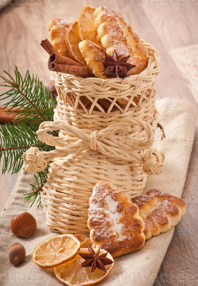 meia de natal de vime cheia de biscoitos, paus de canela, limão cristalizado e anis estrelado foto