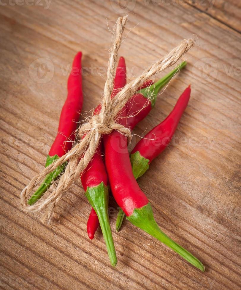 red hot chili peppers amarrado com corda na tigela de madeira foto