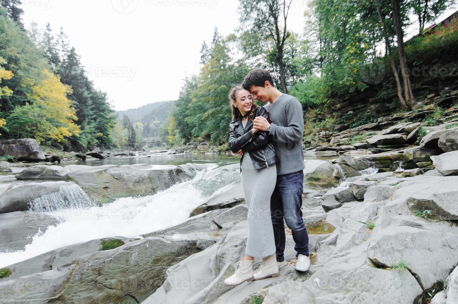 casal incrivelmente lindo e adorável no fundo de um rio de montanha foto