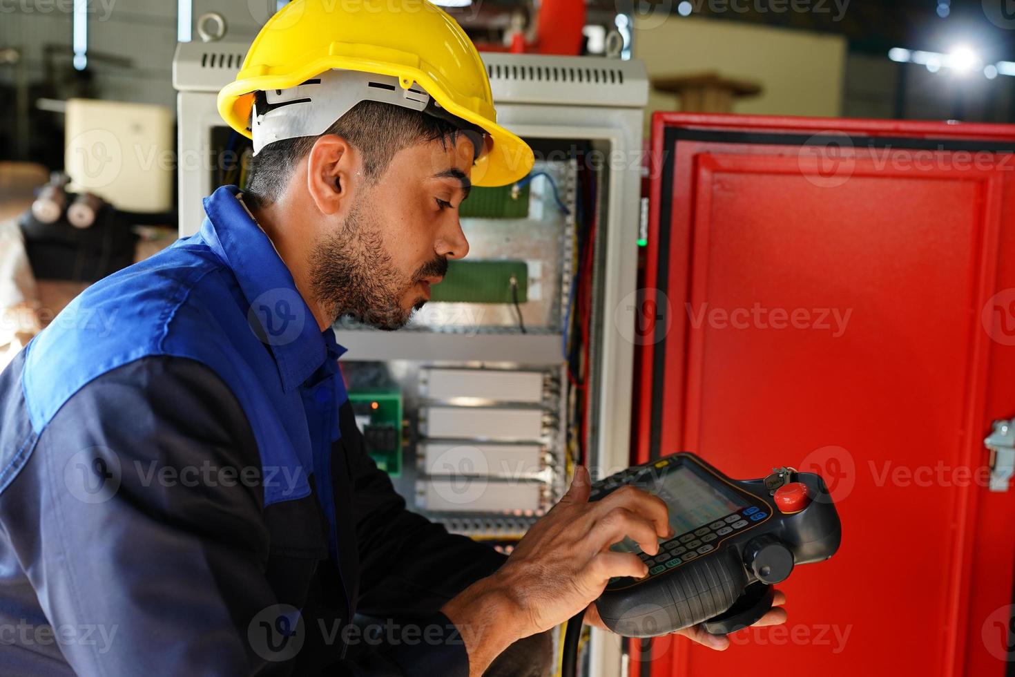 funcionário de fábrica industrial profissional trabalhando com peça de máquina, verificando e testando equipamentos industriais e braços robóticos em grande fábrica de plantas de fabricação de fios e cabos eletrônicos elétricos foto