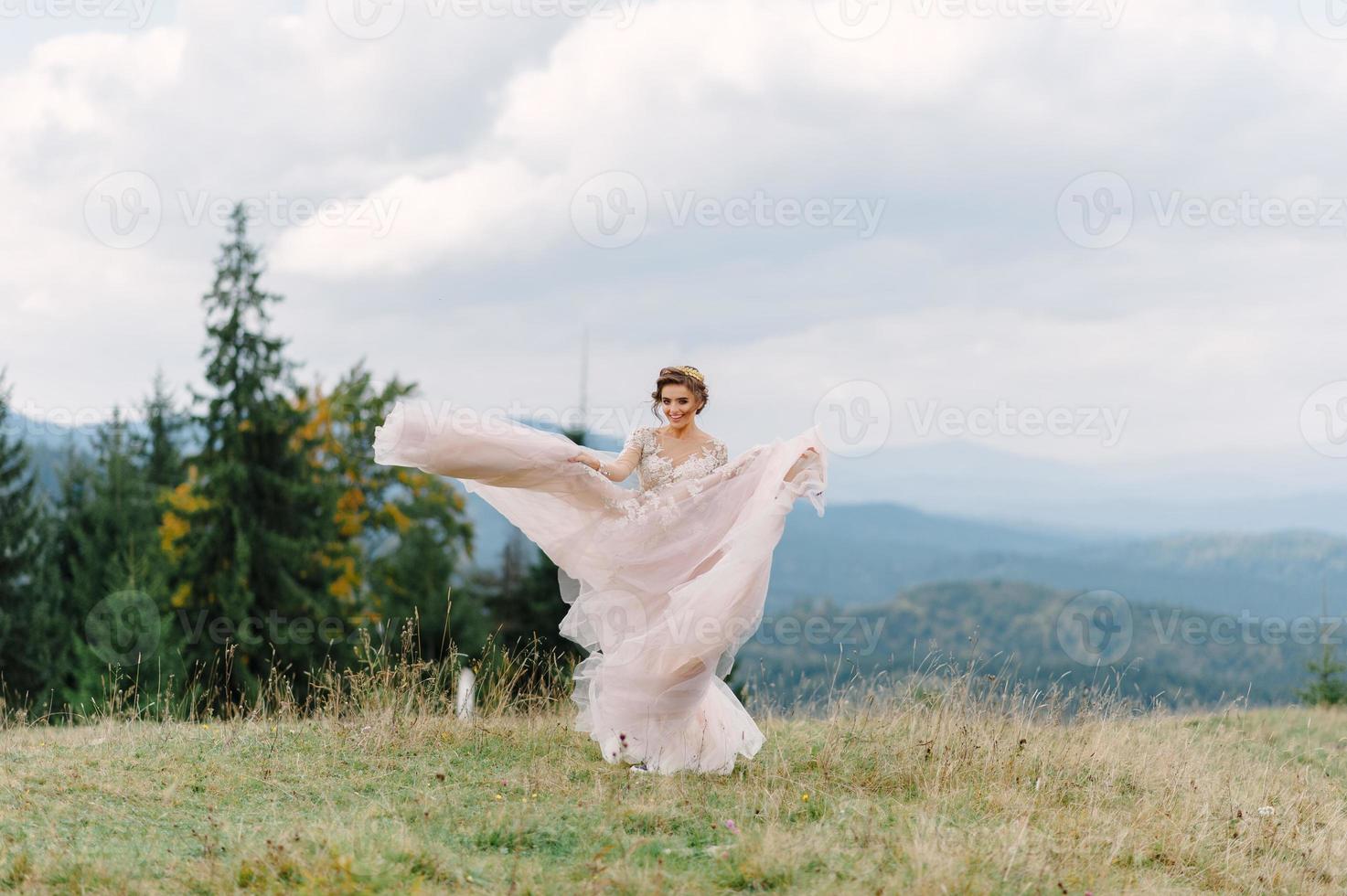 girando noiva segurando a saia véu do vestido de noiva na floresta de pinheiros foto