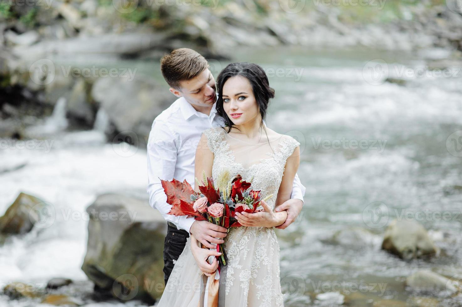 noiva e noivo. cerimônia de casamento perto de um rio de montanha foto