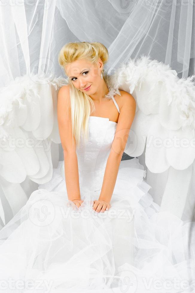 mulher loira sexy fantasiada de anjo posando na frente da câmera. foto