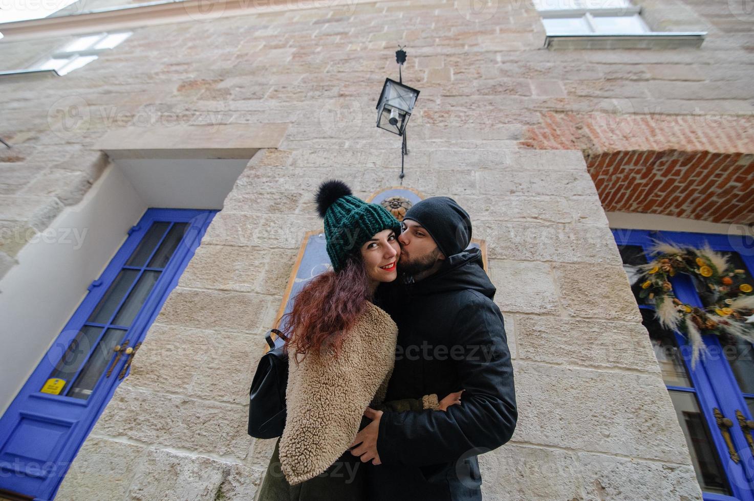 jovem casal feliz de amantes no início da história de amor - homem bonito sussurra beijos suaves no ouvido de mulher bonita - conceito de moda outono com namorado e namorada em um olhar filtrado vintage frio foto