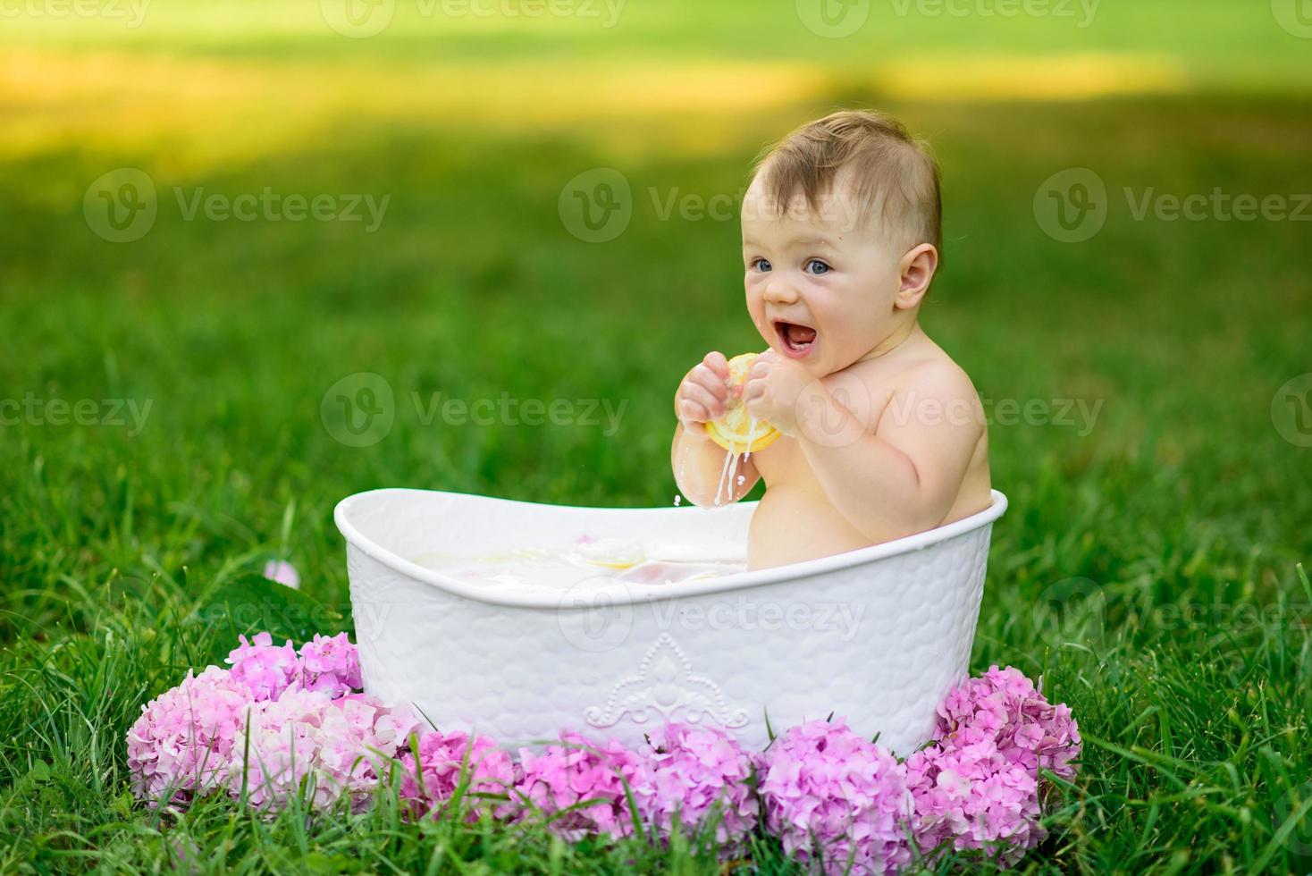 menina toma banho em um banho de leite no parque. a garota está se divertindo no verão. foto