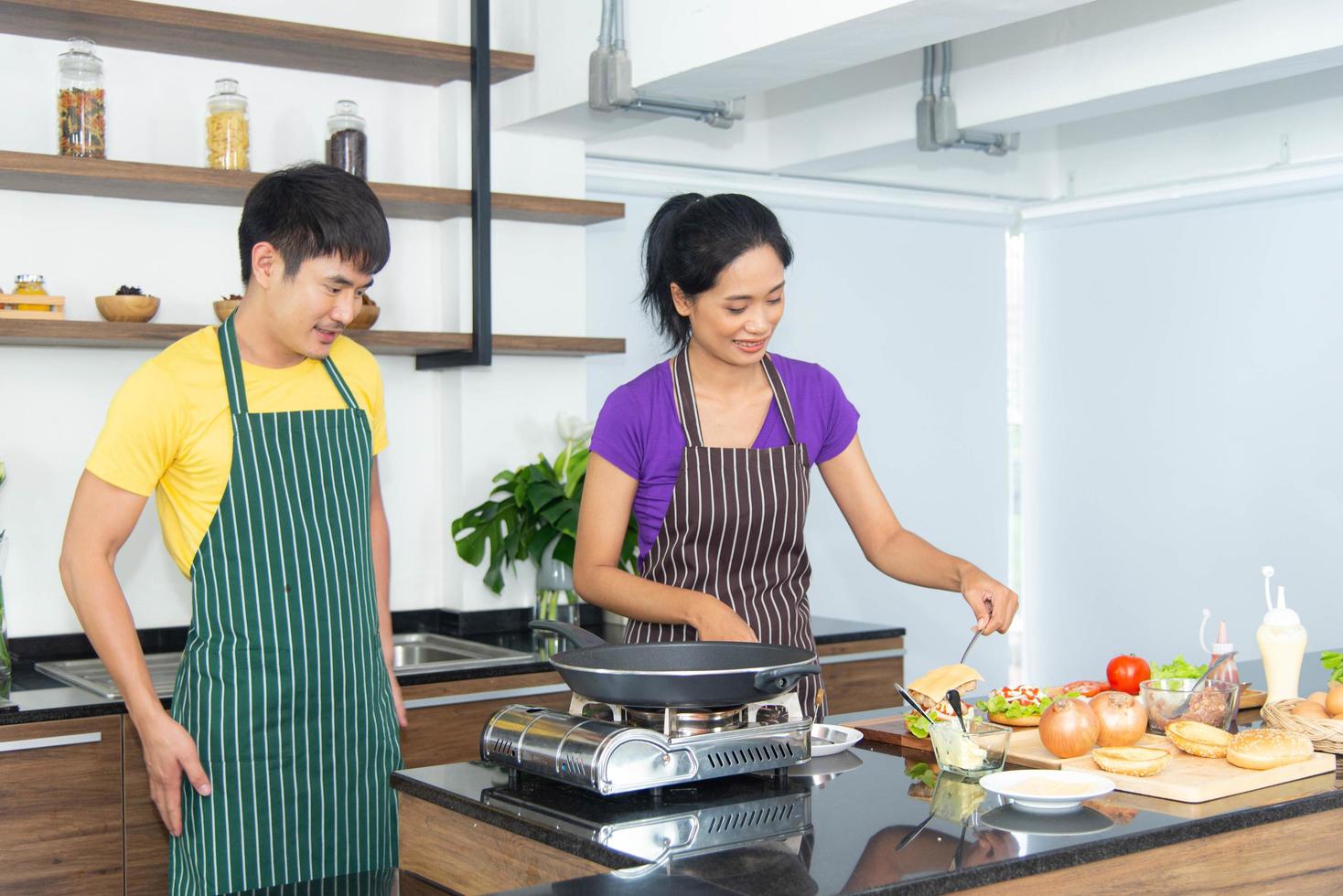 casal romântico e adorável asiático gosta e feliz cozinhando comida na cozinha foto