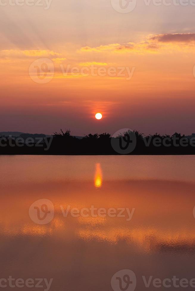 belo pôr do sol sobre o lago no verão foto