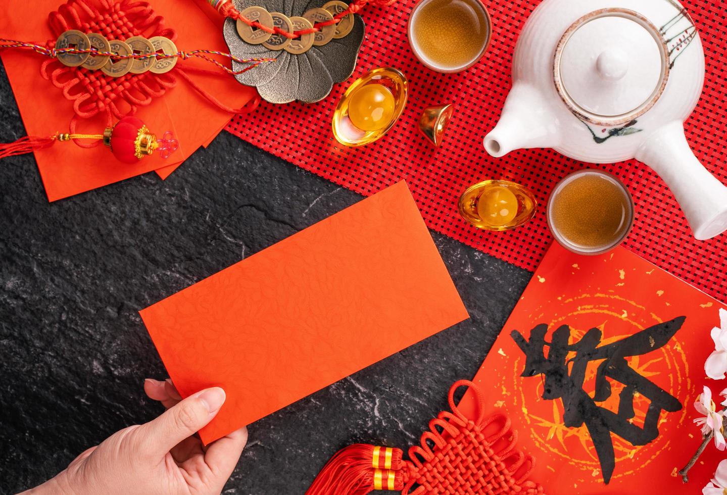 conceito de design do ano novo de janeiro lunar chinês - mulher segurando, dando envelopes vermelhos ang pow, hong bao por dinheiro da sorte, vista superior, postura plana, sobrecarga acima. a palavra chun significa a chegada da primavera. foto