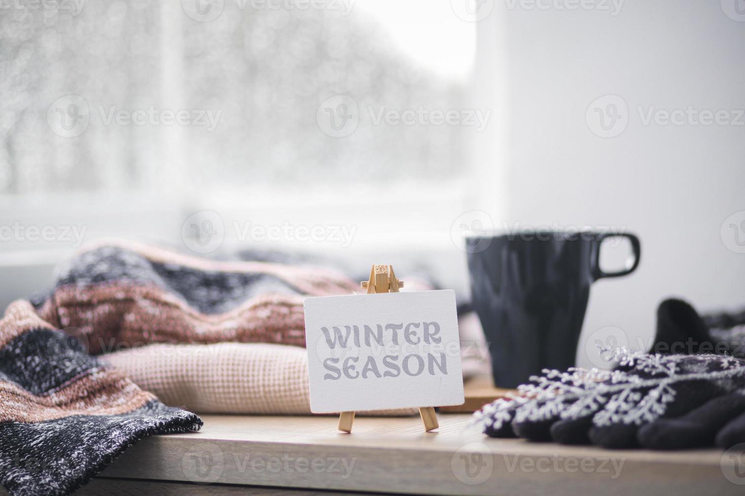 luvas de inverno, gorro e suéter com uma xícara de café para dar as boas-vindas ao inverno foto