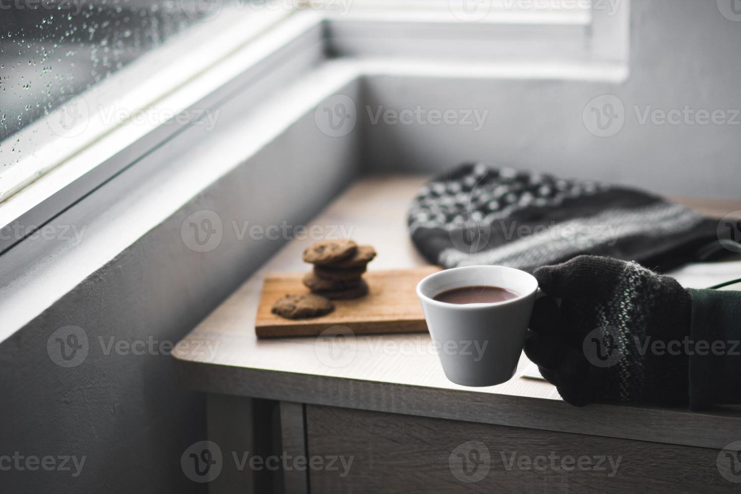 mãos com luvas de inverno segurando uma xícara de chocolate quente foto