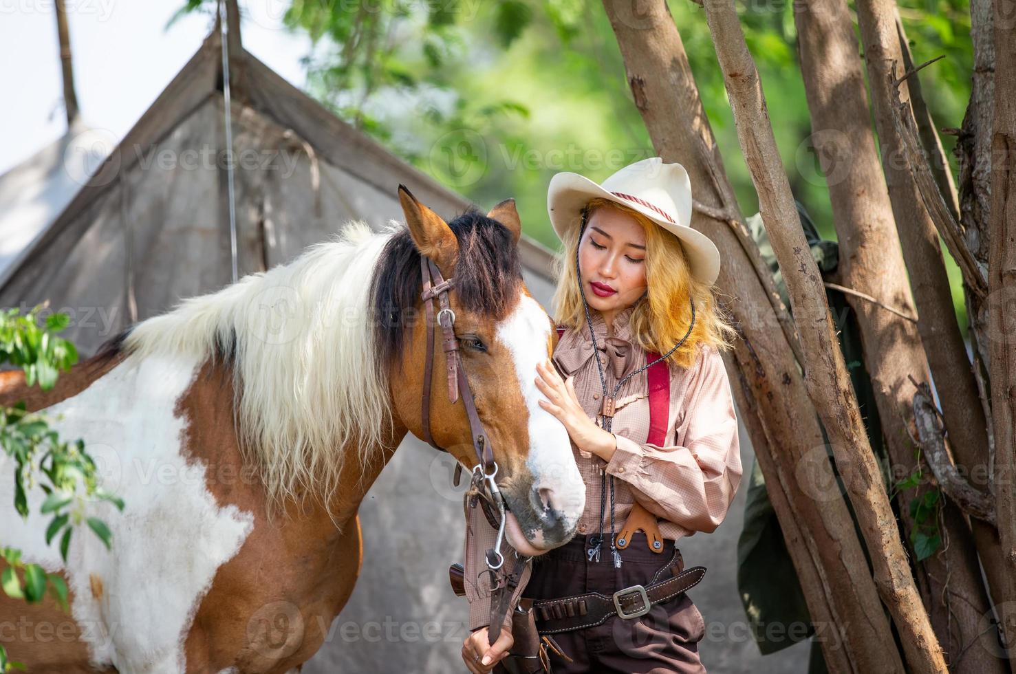 jovem e bonita com seu cavalo na luz do sol à noite. fotografia ao ar livre com garota modelo de moda. humor de estilo de vida foto