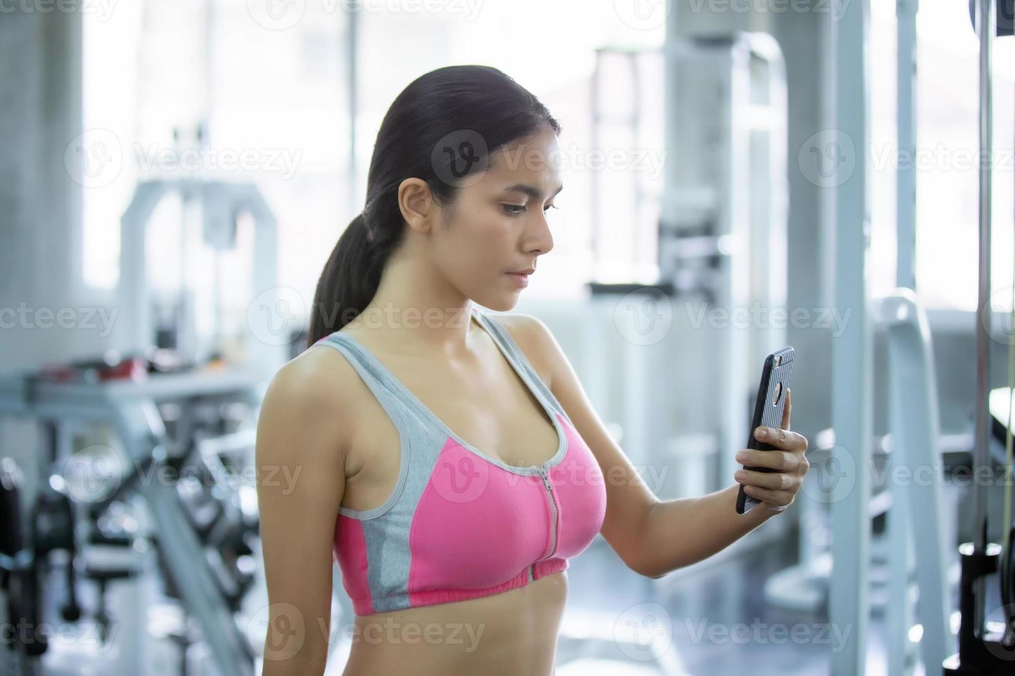 mulher jovem corpo magro relaxa após treino no ginásio de fitness. foto
