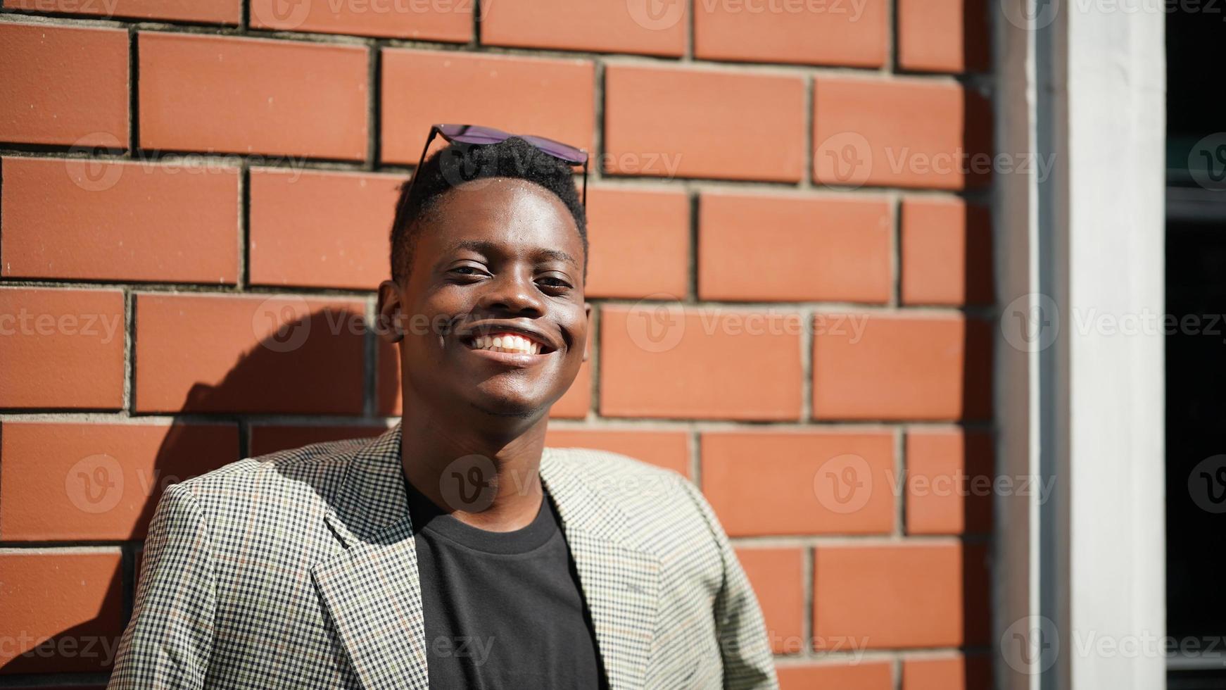 homem afro-americano se divertindo andando no centro da cidade - cara jovem feliz aproveitando o tempo um pôr do sol ao ar livre - estilo de vida da geração milenar e conceito de atitude positiva das pessoas foto