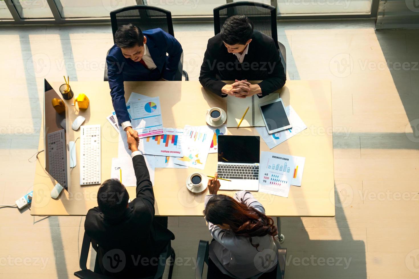 vista superior em um grupo de empresário e empresária tendo uma reunião e assumindo um compromisso comercial. foto