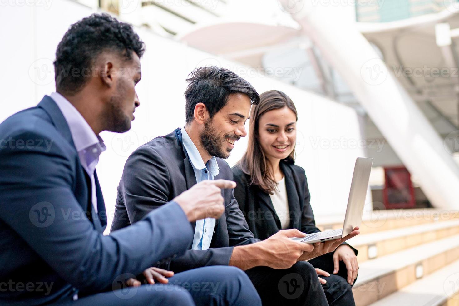 colegas discutindo a atividade de negócios no laptop ao ar livre. foto