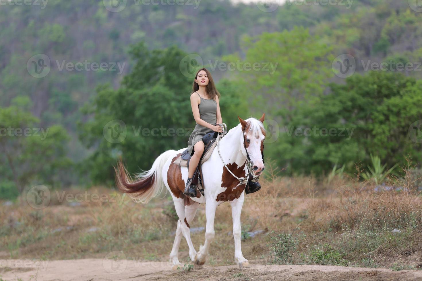 jovem e bonita com seu cavalo na luz do sol à noite. fotografia ao ar livre com garota modelo de moda. humor de estilo de vida foto