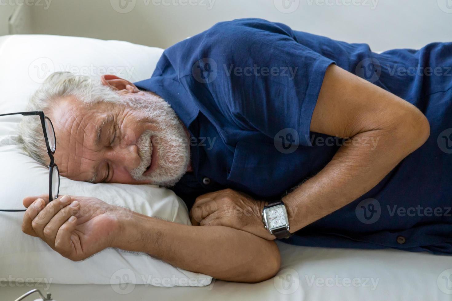 homem idoso repetido com cabelos grisalhos está dormindo no quarto durante o dia para relaxar. foto