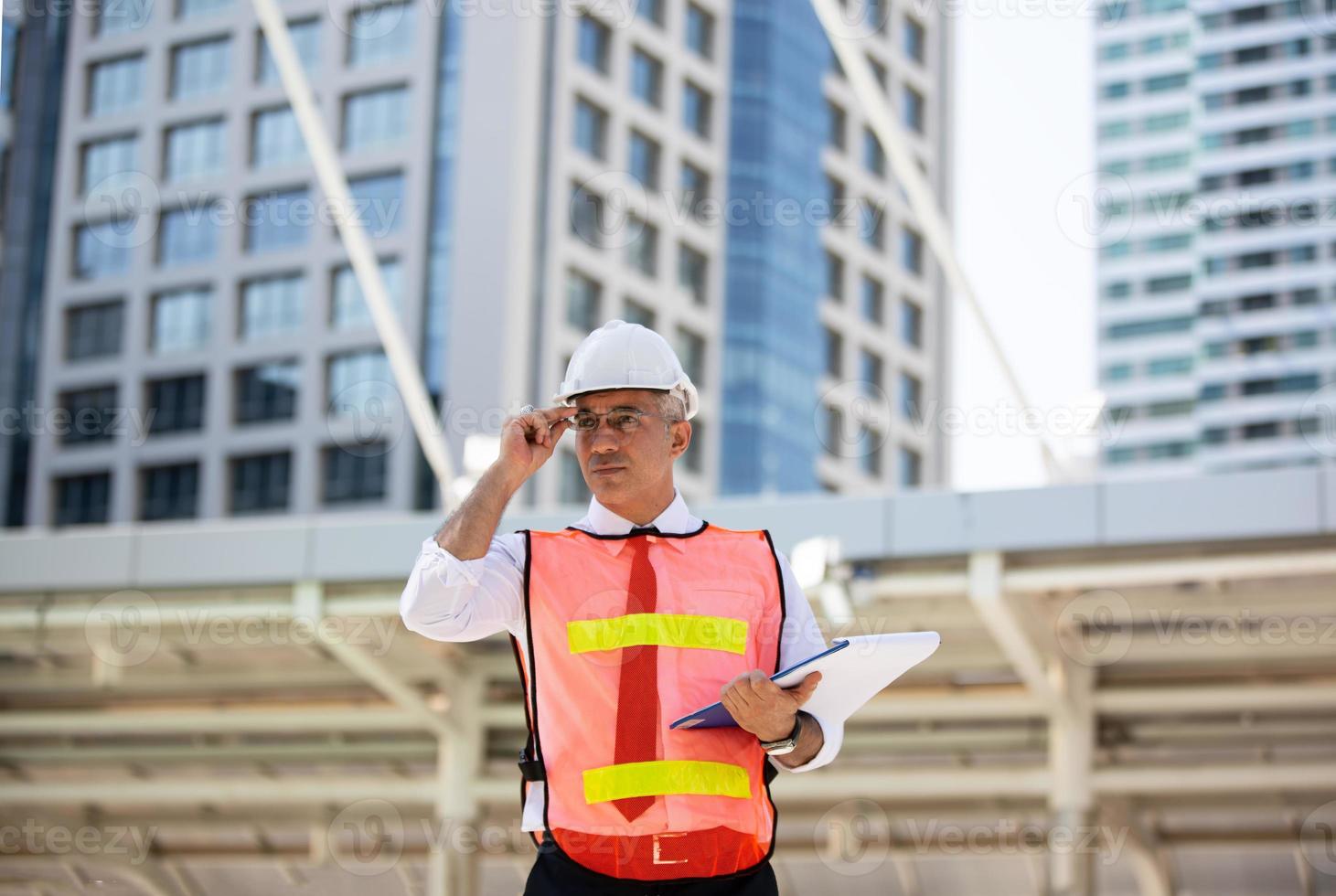 o engenheiro verificando na área de transferência no prédio do canteiro de obras. o conceito de engenharia, construção, vida urbana e futuro. foto