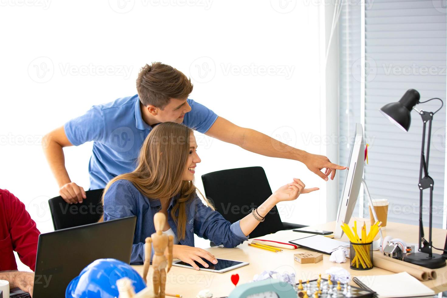 grupo diversificado de jovens empresários discutindo um projeto de trabalho enquanto estão sentados juntos em uma mesa em um escritório moderno. conceito de coworking foto