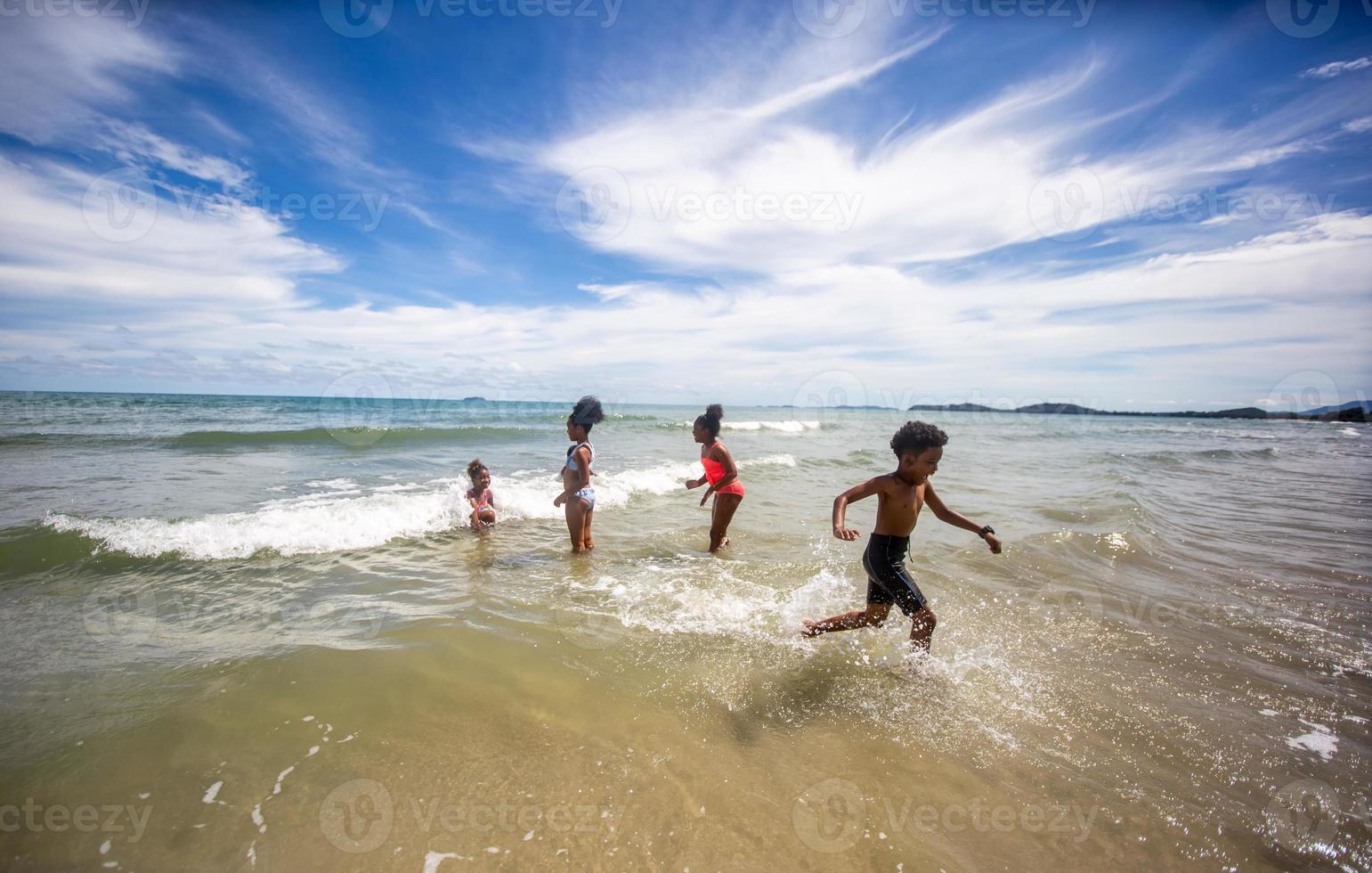 crianças brincando correndo na areia da praia foto