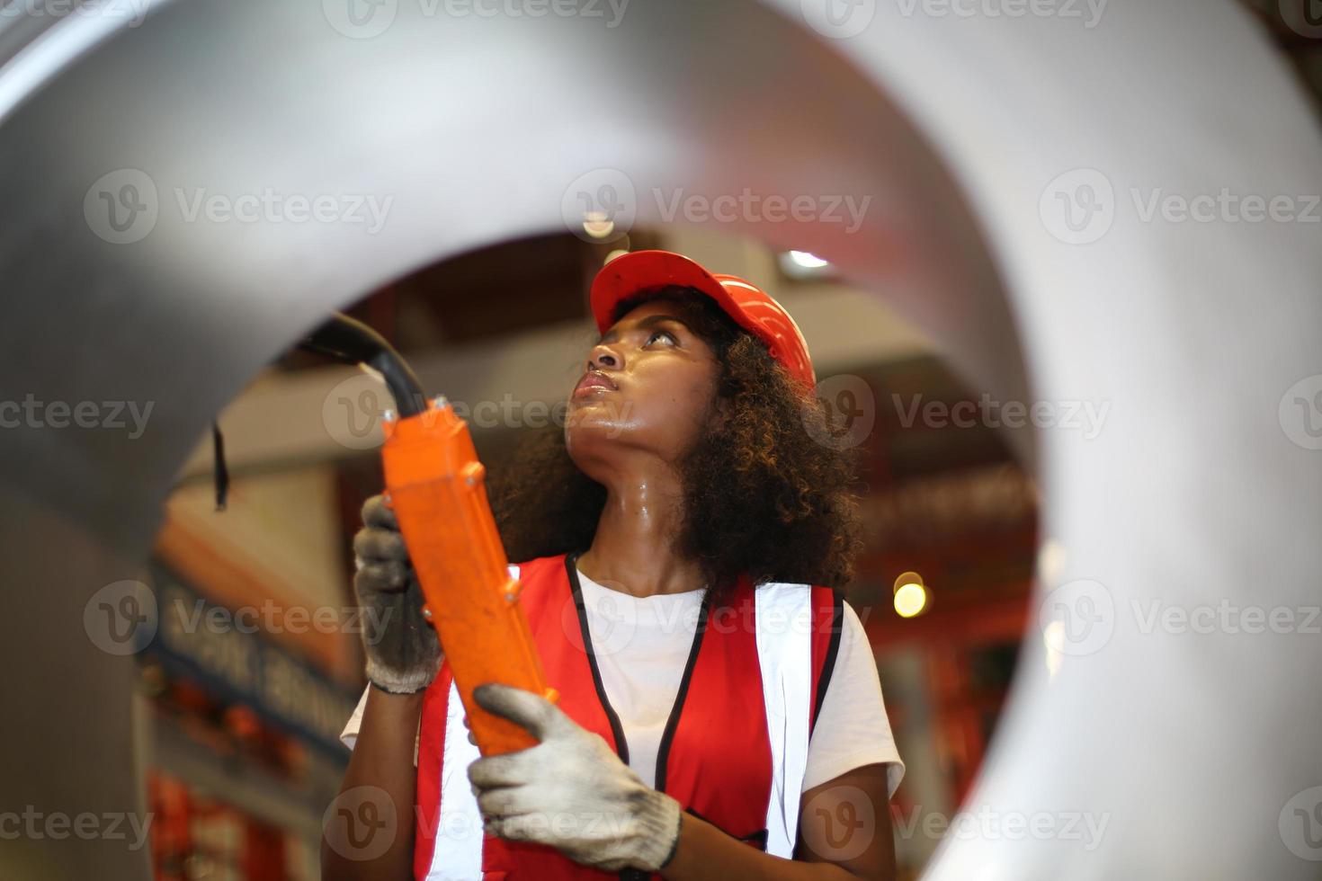 capataz de trabalhadora ou trabalhadora trabalha no local da fábrica, verifique a máquina ou os produtos no local. engenheiro ou técnico verificando material ou máquina na planta. industriais e fabris. foto