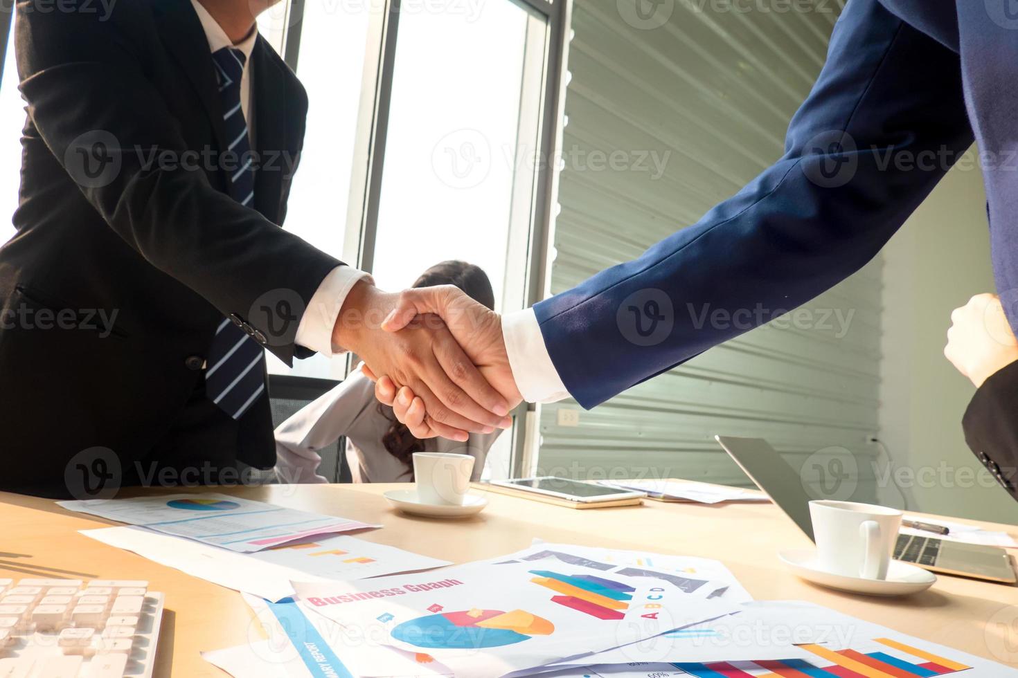 empresários apertando as mãos no escritório moderno terminando reunião bem sucedida foto