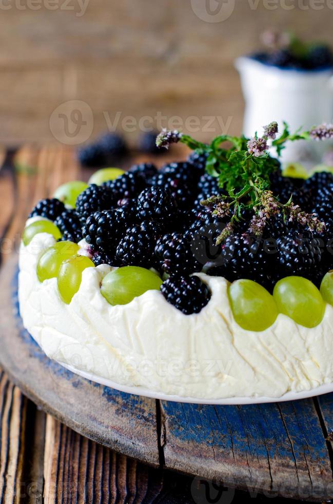 cheesecake com amoras e uvas em uma mesa de madeira velha foto