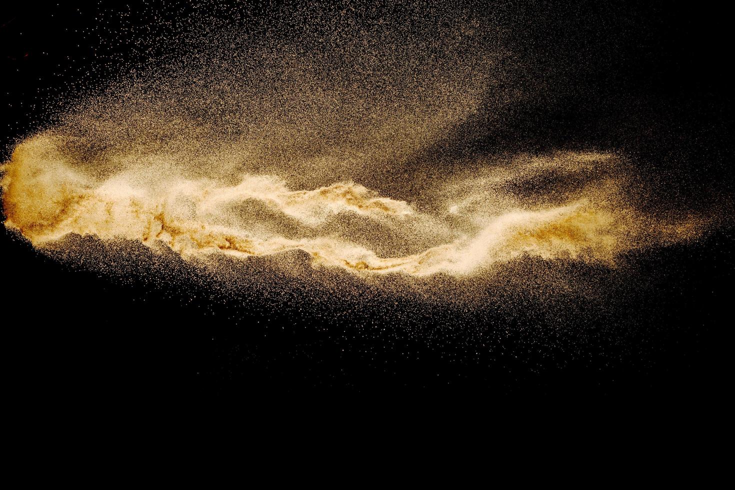 explosão de areia seca do rio isolada no fundo preto. areia abstrata cloud.brown respingo de areia colorido contra um fundo escuro. foto