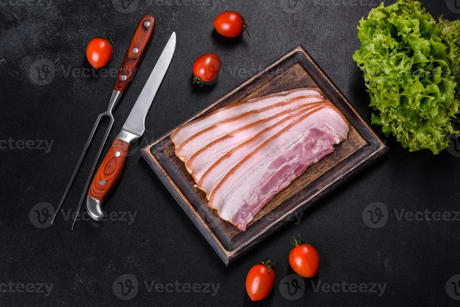 fatias de bacon em uma tábua de madeira. carne de porco foto