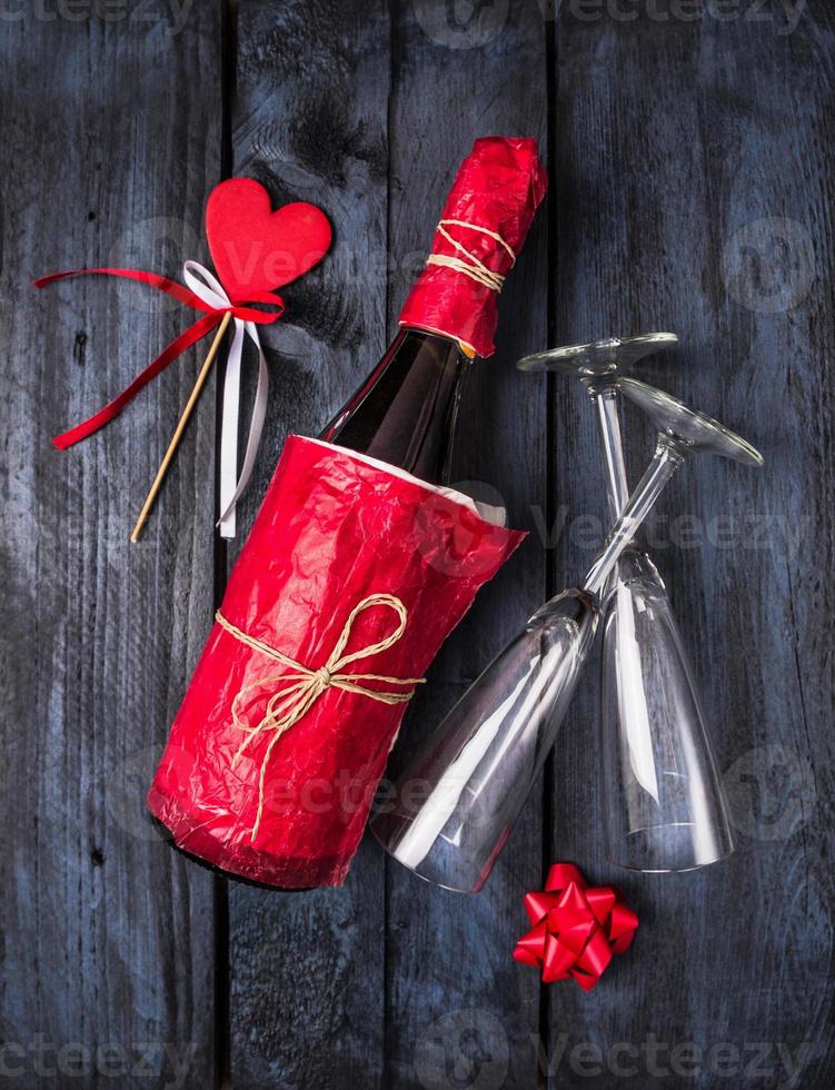 garrafa de champanhe em papel vermelho, coração em fundo azul foto